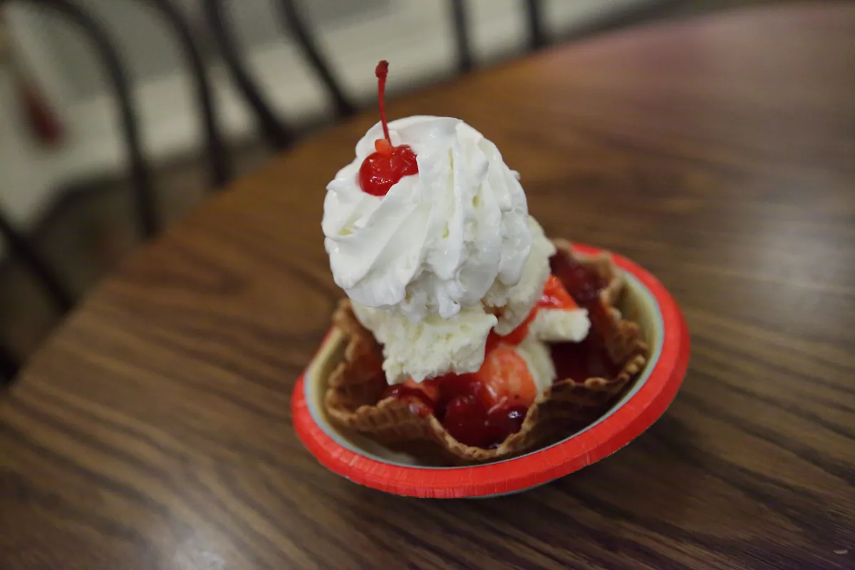 Strawberry sundae with whipped cream in a waffle bowl